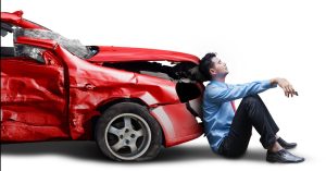 Man Sitting Againts Crashed Car | Red Car Crash | Rinehardt Injury Attorneys